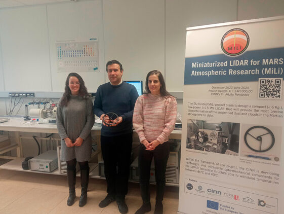 Investigadores del CINN en el proyecto MiLi muestran el soporte del espejo secundario (Spider) del LiDAR. De izquierda a derecha: Noemí López, Adolfo Fernández y Marta Suárez. Fuente: CINN